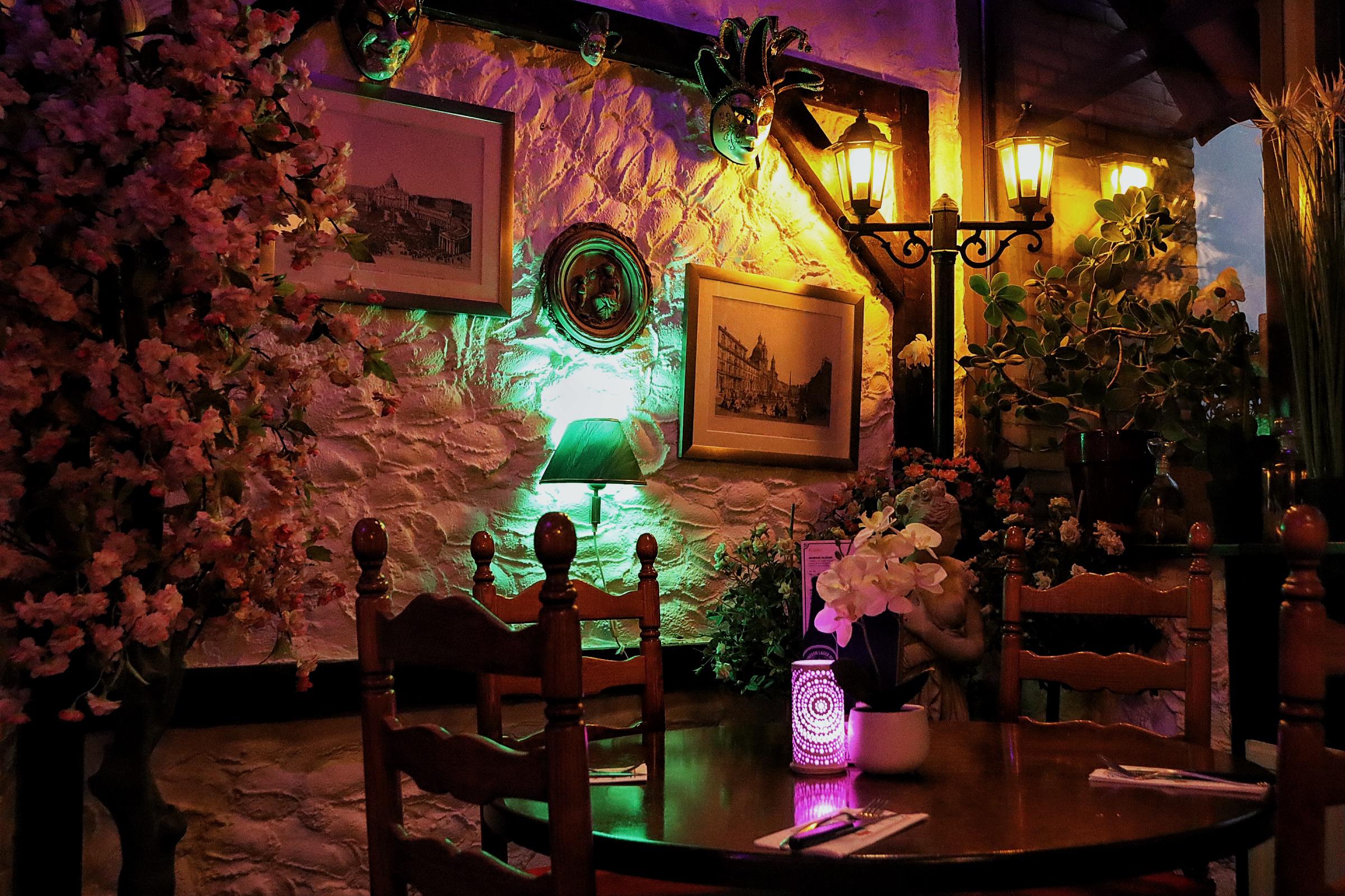 Intieme eethoek Restaurant Romagna - Authentieke Italiaanse stenen muur met groene accent verlichting